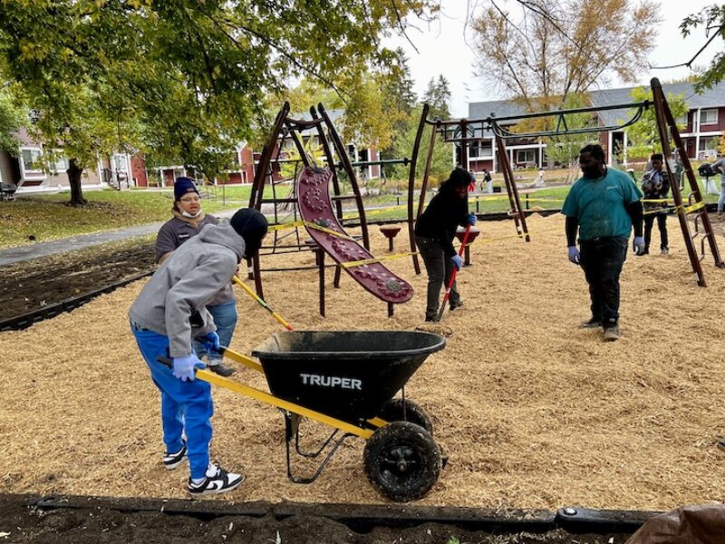Young people working together to add mulch to playground