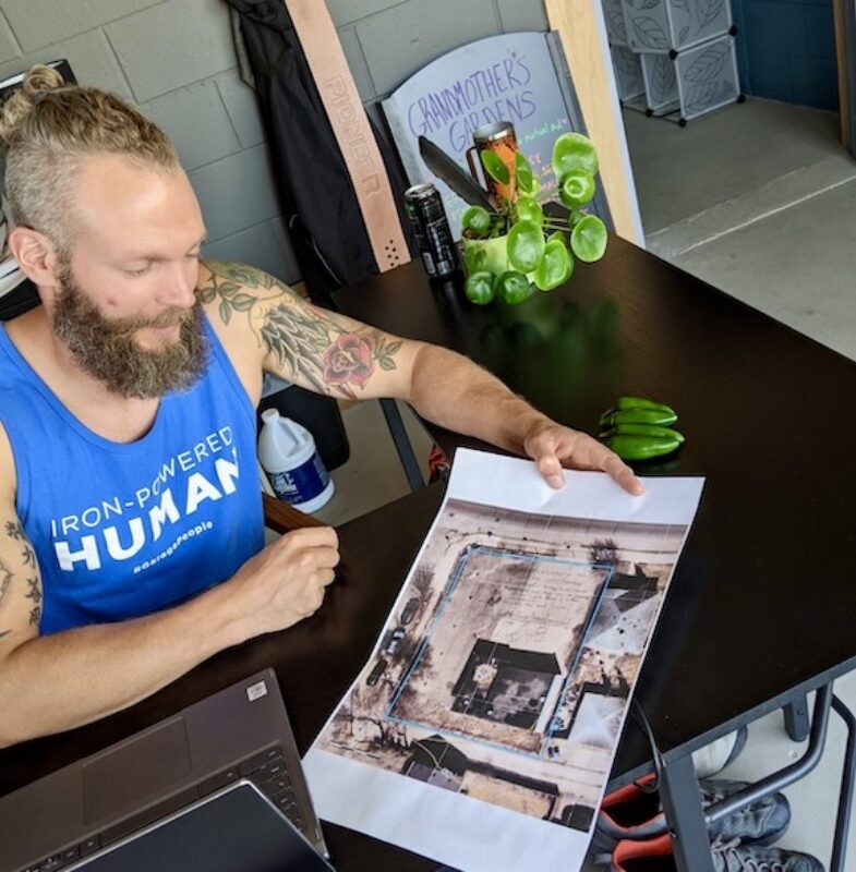 Business owner Ben Swarts looks at a design plan for his business' outdoor area