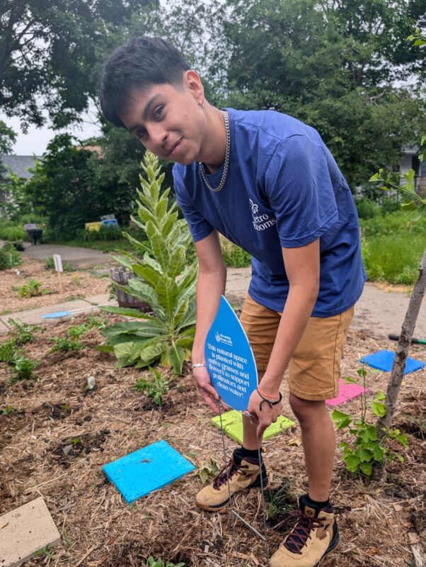 Person getting ready to put sign in garden