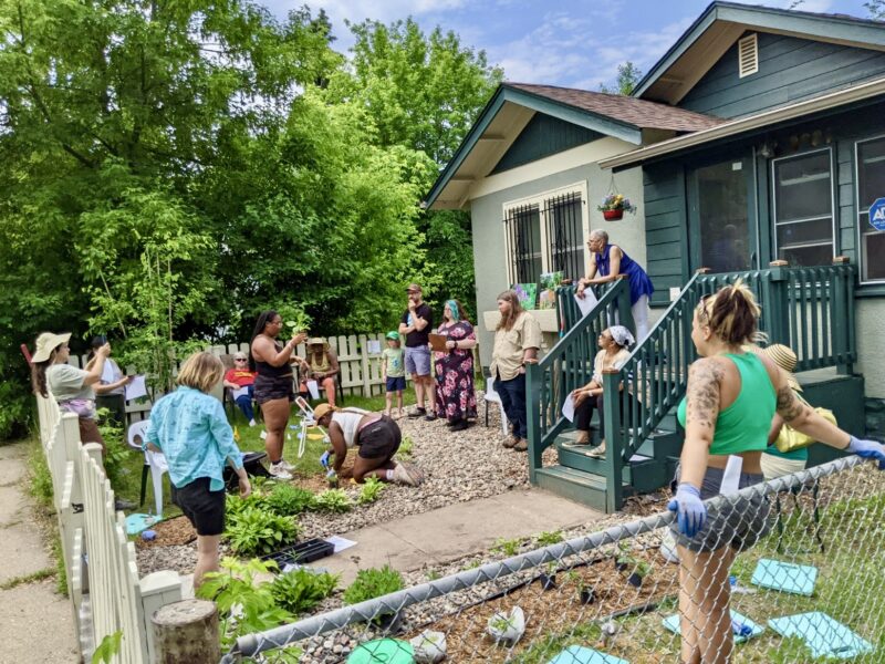 People in a front yard learning about gardening