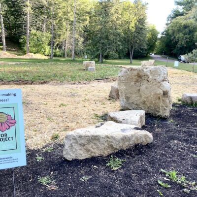 Large rocks near Turf to Pollinator Garden sign in pollinator garden ready to be planted