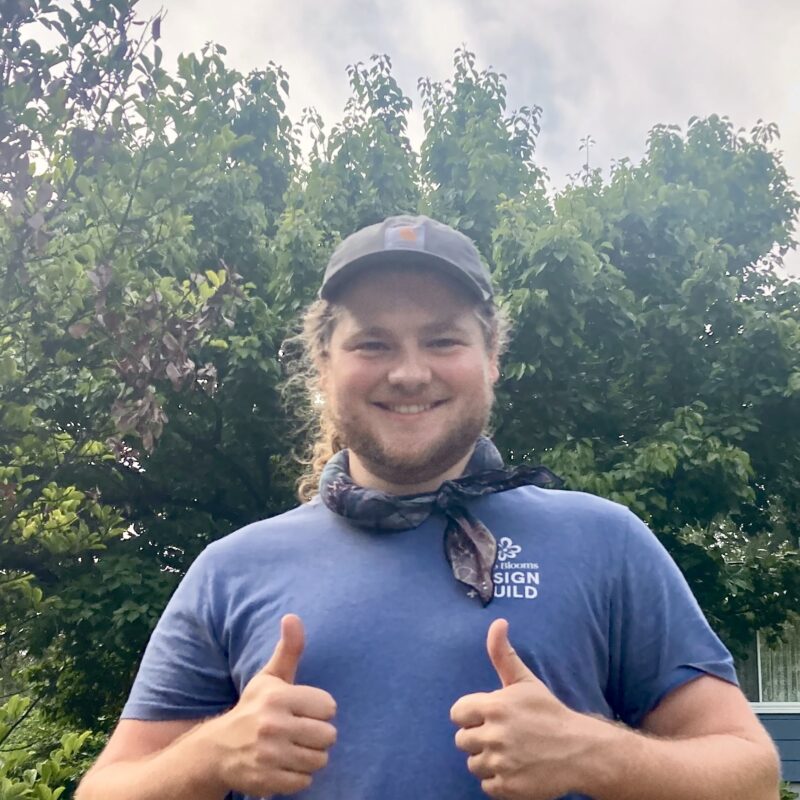 Head and shoulders smiling person in tshirt showing thumbs up