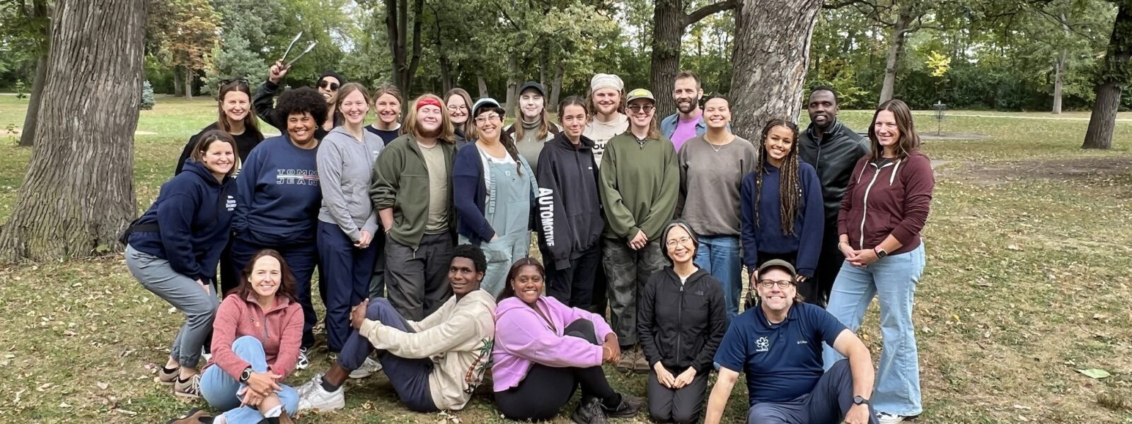 Large group people posing for photo in a park